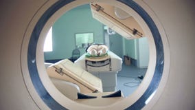 Непознаваемый стационарный больной лежа на MRI, томограф, блок развертки, двигая к и от камеры Всход слайдера Непознаваемый стационарный больной лежа на MRI, томограф, блок развертки, двигая к и от камеры Всход слайдера