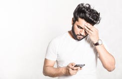 Неприятно удивленное сообщение чтения человека на смартфоне стоковые фото Неприятно удивленное сообщение чтения человека на смартфоне стоковые фото