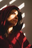 Несчастная девушка стоит одной на шторках окна стоковая фотография Несчастная девушка стоит одной на шторках окна стоковая фотография