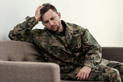 Несчастный и унылый солдат в зеленой форме moro с синдромом войны стоковое изображение Несчастный и унылый солдат в зеленой форме moro с синдромом войны стоковое изображение