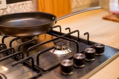 Новая сковорода на совершенно новых панелях газовой плиты Газовая плита горелки классики 4 с латунными ручками Селективный фокус стоковая фотография Новая сковорода на совершенно новых панелях газовой плиты Газовая плита горелки классики 4 с латунными ручками Селективный фокус стоковая фотография