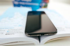 Новый smartphone корабля- флагмана Яблока Iphone x помещенный на книге перемещения стоковое фото Новый smartphone корабля- флагмана Яблока Iphone x помещенный на книге перемещения стоковое фото