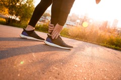 Нога атлетического бегуна человека касающая в боли должной к sprained лодыжке стоковое фото rf Нога атлетического бегуна человека касающая в боли должной к sprained лодыжке стоковое фото rf