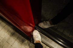 Нога женщины с белыми ботинками смотрит сверху с отражением себя в черном зеркале с красной структурой стоковые фотографии rf Нога женщины с белыми ботинками смотрит сверху с отражением себя в черном зеркале с красной структурой стоковые фотографии rf