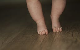 Ноги newborn конца младенца вверх на изолированной деревянной предпосылке стоковая фотография Ноги newborn конца младенца вверх на изолированной деревянной предпосылке стоковая фотография