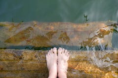 Ноги и Pedicure женщины в зеленой воде, взгляд сверху пурпура Красивые азиатские ноги женского тела детенышей и босоногий на дере стоковое фото rf Ноги и Pedicure женщины в зеленой воде, взгляд сверху пурпура Красивые азиатские ноги женского тела детенышей и босоногий на дере стоковое фото rf