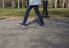 Ноги людей идя в ботинки спорт вниз по улице на солнечный день стоковые изображения Ноги людей идя в ботинки спорт вниз по улице на солнечный день стоковые изображения