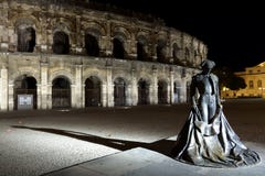Ночь осматривает арену Nîmes и статую матадора стоковое фото rf Ночь осматривает арену Nîmes и статую матадора стоковое фото rf