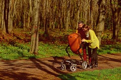 Няни идут с pram младенца в парке Няни женщины и человека позаботятся о меньший ребенок Ответственность и стоковые фото Няни идут с pram младенца в парке Няни женщины и человека позаботятся о меньший ребенок Ответственность и стоковые фото