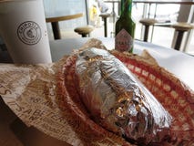 Обернутое буррито с питьем и зеленым цветом Табаско на Chipotle стоковое фото rf Обернутое буррито с питьем и зеленым цветом Табаско на Chipotle стоковое фото rf