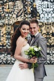 Обнимать новобрачных перед стробами стоковая фотография rf Обнимать новобрачных перед стробами стоковая фотография rf