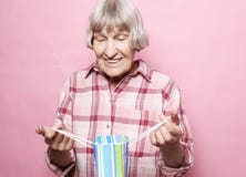 Образ жизни и концепция людей: Счастливая старшая женщина с хозяйственной сумкой над розовой предпосылкой стоковые изображения rf Образ жизни и концепция людей: Счастливая старшая женщина с хозяйственной сумкой над розовой предпосылкой стоковые изображения rf