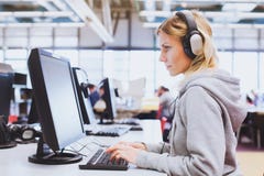 Обучение взрослых, студент в наушниках работая на компьютере в библиотеке стоковое фото rf Обучение взрослых, студент в наушниках работая на компьютере в библиотеке стоковое фото rf