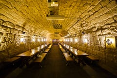 Огромная комната вполне деревянных столов украшенных с кирпичными стенами и лампами года сбора винограда стоковое изображение Огромная комната вполне деревянных столов украшенных с кирпичными стенами и лампами года сбора винограда стоковое изображение