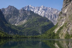 Озеро с кристально ясными горами воды весной Небольшое озеро во взгляде Альп от одного берега Отражение гор внутри стоковое изображение Озеро с кристально ясными горами воды весной Небольшое озеро во взгляде Альп от одного берега Отражение гор внутри стоковое изображение