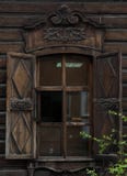 Окно с деревянным высекаенным architrave в старом деревянном доме в старом русском городке стоковая фотография Окно с деревянным высекаенным architrave в старом деревянном доме в старом русском городке стоковая фотография