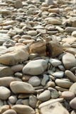 Округленные камешки на пляже Бежевые камешки на пляже и каменном разделении в половине стоковые фотографии rf Округленные камешки на пляже Бежевые камешки на пляже и каменном разделении в половине стоковые фотографии rf