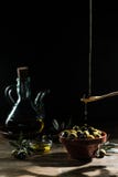 Оливковое масло и оливковая ветка на деревянном столе стоковые фотографии rf Оливковое масло и оливковая ветка на деревянном столе стоковые фотографии rf