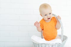 Он ягнится сидит в корзине смеясь над и развевая его оружия и ногами стоковые фотографии rf Он ягнится сидит в корзине смеясь над и развевая его оружия и ногами стоковые фотографии rf