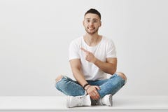 Оно не было мной, им было им Крытая съемка смущенного милого парня в стильном обмундировании сидя на поле с пересеченный стоковые изображения Оно не было мной, им было им Крытая съемка смущенного милого парня в стильном обмундировании сидя на поле с пересеченный стоковые изображения