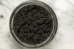 Опарник с очень вкусной черной икрой на серой предпосылке стоковое фото rf Опарник с очень вкусной черной икрой на серой предпосылке стоковое фото rf