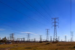 Опоры электричества против голубого неба на грубой земле стоковое фото rf Опоры электричества против голубого неба на грубой земле стоковое фото rf