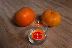 Оранжевые pumkins с красочной свечой в стекле на деревянных досках стоковое изображение rf Оранжевые pumkins с красочной свечой в стекле на деревянных досках стоковое изображение rf