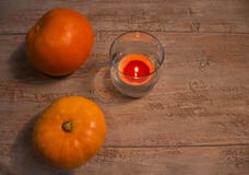 Оранжевые pumkins с красочной свечой в стекле на деревянных досках стоковая фотография rf Оранжевые pumkins с красочной свечой в стекле на деревянных досках стоковая фотография rf