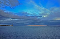 Оранжевый заход солнца между Сине-голубым небом осени над морем около маяка на Крыме стоковые фото Оранжевый заход солнца между Сине-голубым небом осени над морем около маяка на Крыме стоковые фото