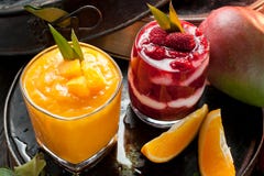 Оранжевый и красный smoothie и оранжевые плоды с зелеными листьями на d стоковые фото Оранжевый и красный smoothie и оранжевые плоды с зелеными листьями на d стоковые фото