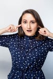 Остановите сделать эту досадную ядровую молодую женщину делая перекошенную сторону, затыкая уши при пальцы, раздражанные с приход стоковое фото rf Остановите сделать эту досадную ядровую молодую женщину делая перекошенную сторону, затыкая уши при пальцы, раздражанные с приход стоковое фото rf