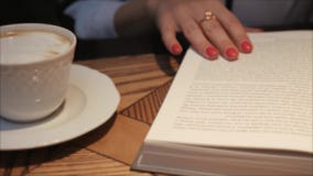 Отверстие молодой женщины и чтение книги пока выпивающ кофе в уютном кафе Дама дела читая книгу r Изучать f сток-видео Отверстие молодой женщины и чтение книги пока выпивающ кофе в уютном кафе Дама дела читая книгу r Изучать f сток-видео