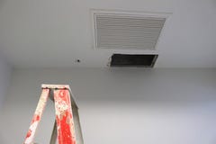 Отверстие панелей потолка в офисе крыши от утечки водоотводных труб с лестницей шага стоковое изображение Отверстие панелей потолка в офисе крыши от утечки водоотводных труб с лестницей шага стоковое изображение