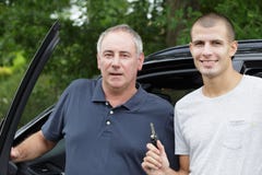 Отец и сын представляя рядом с автомобилем стоковые изображения Отец и сын представляя рядом с автомобилем стоковые изображения