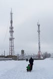 Отец с детьми на скелетоне идет к башне ТВ и башне клетки в тумане туманная зима утра стоковое фото Отец с детьми на скелетоне идет к башне ТВ и башне клетки в тумане туманная зима утра стоковое фото
