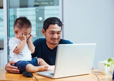Отец человека работая на ноутбуке стоковая фотография Отец человека работая на ноутбуке стоковая фотография