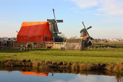 Отключение весны к Zaanse Schans Спокойные каналы, спокойные реки пропускают между холмами Голландские ветрянки стоят как традици стоковые фотографии rf Отключение весны к Zaanse Schans Спокойные каналы, спокойные реки пропускают между холмами Голландские ветрянки стоят как традици стоковые фотографии rf