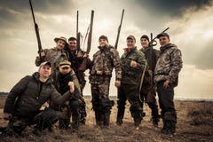Охотники стоя совместно против неба восхода солнца в сельском поле во время сезона звероловства Концепция для сыгранности стоковые изображения rf Охотники стоя совместно против неба восхода солнца в сельском поле во время сезона звероловства Концепция для сыгранности стоковые изображения rf