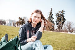 Очаровательная женщина в наушниках слушая к музыке на лужайке Стоковое Фото Очаровательная женщина в наушниках слушая к музыке на лужайке Стоковое Фото