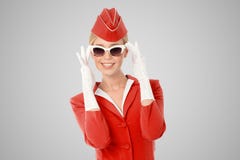 Очаровательный Stewardess в красных равномерных и винтажных солнечных очках стоковые изображения Очаровательный Stewardess в красных равномерных и винтажных солнечных очках стоковые изображения