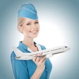 Очаровательный Stewardess держа самолет в руке. стоковое изображение rf Очаровательный Stewardess держа самолет в руке. стоковое изображение rf