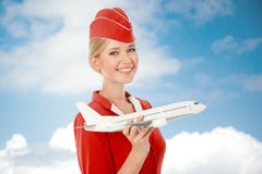 Очаровательный Stewardess держа самолет в руке стоковое фото rf Очаровательный Stewardess держа самолет в руке стоковое фото rf