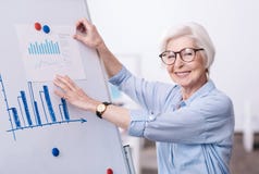 Очаровывая постаретая коммерсантка работая на проекте в офисе стоковое изображение rf Очаровывая постаретая коммерсантка работая на проекте в офисе стоковое изображение rf