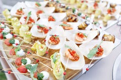 Очень вкусная креветка и отрезанные томаты на деревянной шлюпке Цукини свертывает с гайками сосны Вкусная таблица шведского стола стоковая фотография rf Очень вкусная креветка и отрезанные томаты на деревянной шлюпке Цукини свертывает с гайками сосны Вкусная таблица шведского стола стоковая фотография rf