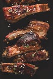 Очень вкусные barbecued нервюры закалённые с пряным наметывая соусом потеряйте-вверх, скопируйте космос стоковое фото rf Очень вкусные barbecued нервюры закалённые с пряным наметывая соусом потеряйте-вверх, скопируйте космос стоковое фото rf