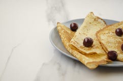 Очень вкусные блинчики с вишней на серой таблице стоковое фото Очень вкусные блинчики с вишней на серой таблице стоковое фото