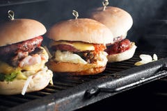 Очень вкусные бургеры с говядиной, томатом, сыром и салатом сваренный на собранном гриле нагрейте гриль и дым стоковые фото Очень вкусные бургеры с говядиной, томатом, сыром и салатом сваренный на собранном гриле нагрейте гриль и дым стоковые фото