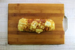 Очень вкусный крен яичниц на деревянной разделочной доске стоковое изображение rf Очень вкусный крен яичниц на деревянной разделочной доске стоковое изображение rf