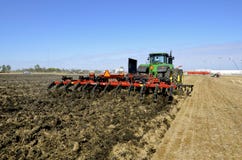 Плужок зубила случая IH и трактор John Deere стоковое изображение Плужок зубила случая IH и трактор John Deere стоковое изображение