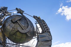 Памятник эмблемы СССР национальной советской сделанной из металла на голубом небе Зверская концепция СССР стоковые изображения rf Памятник эмблемы СССР национальной советской сделанной из металла на голубом небе Зверская концепция СССР стоковые изображения rf